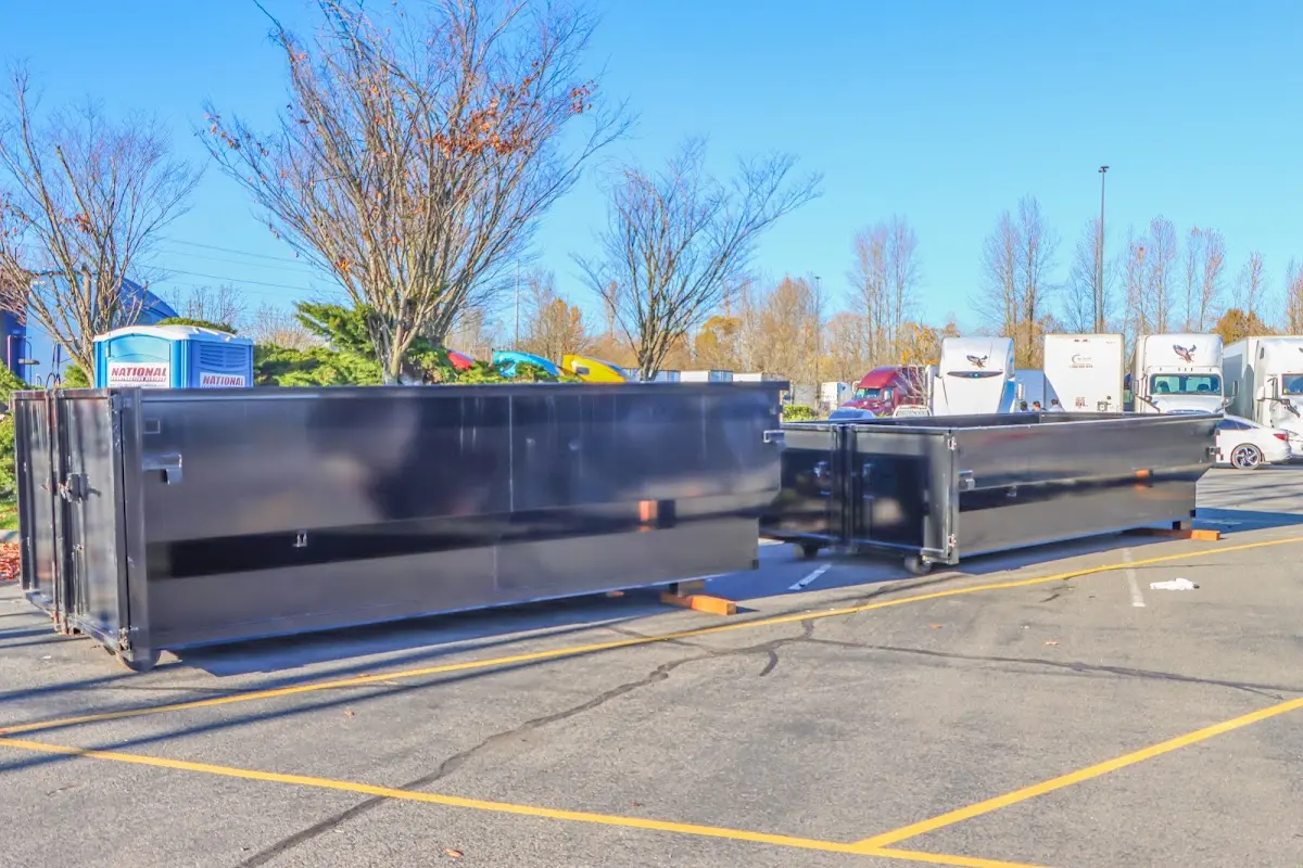 Professional dumpster rental service with roll-off container on residential driveway in Booneville